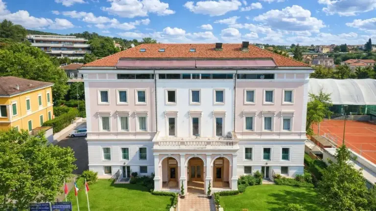 a large white building with a red roof at Greif Hotel & Spa in Trieste