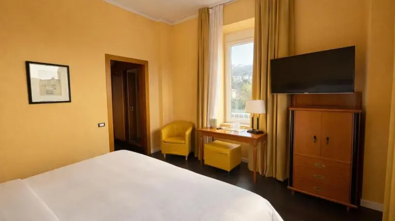 a hotel room with a bed and a television at Greif Hotel & Spa in Trieste