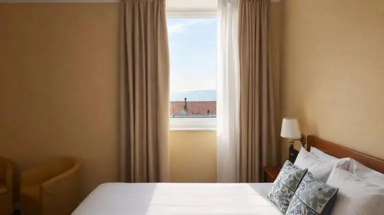a hotel room with two beds with yellow pillows at Greif Hotel & Spa in Trieste