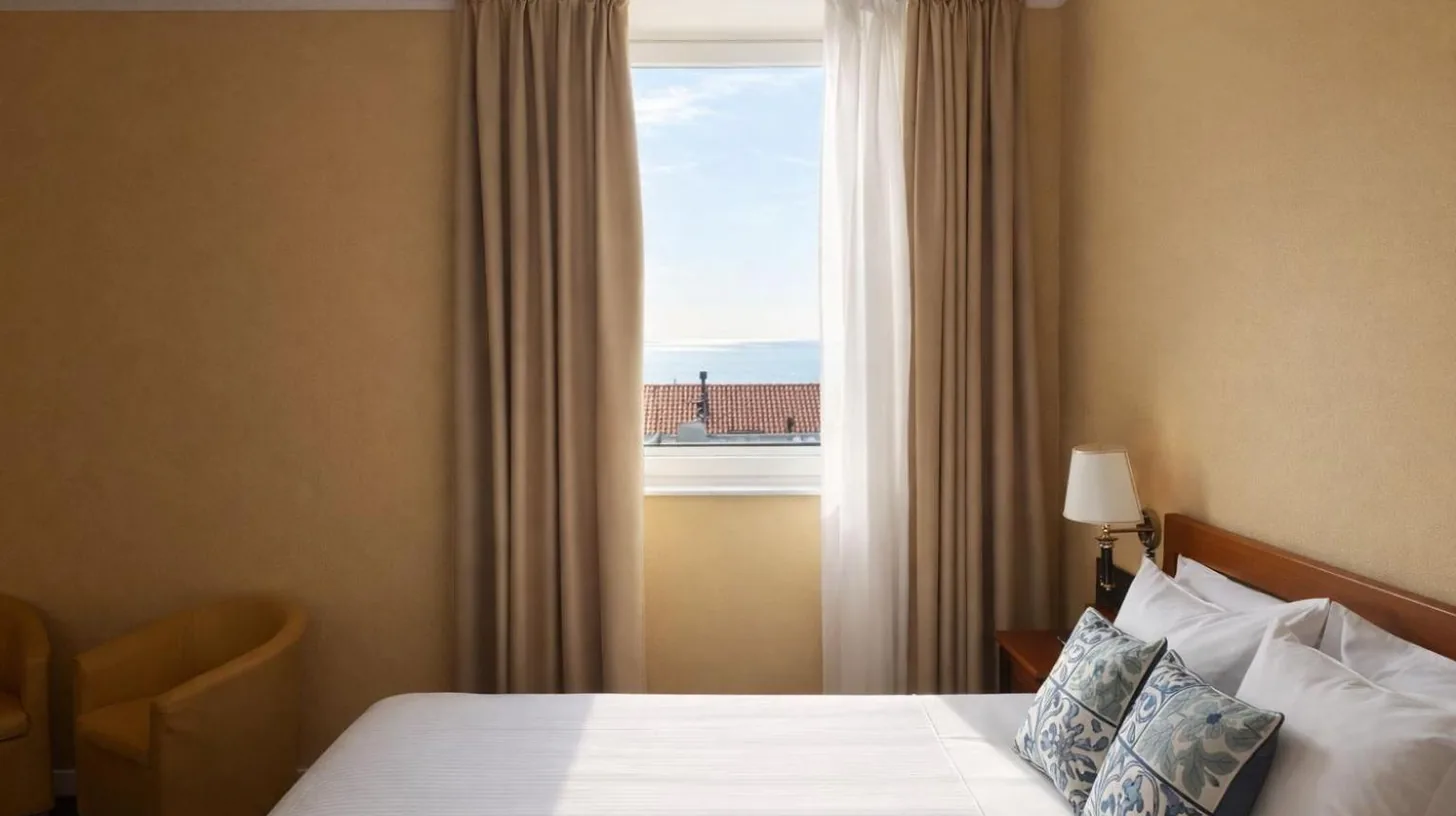 a hotel room with two beds with yellow pillows at Greif Hotel & Spa in Trieste