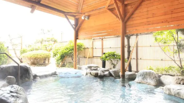 a large swimming pool with a wooden roof at Heiseikan Shiosaitei Hanatsuki in Hakodate