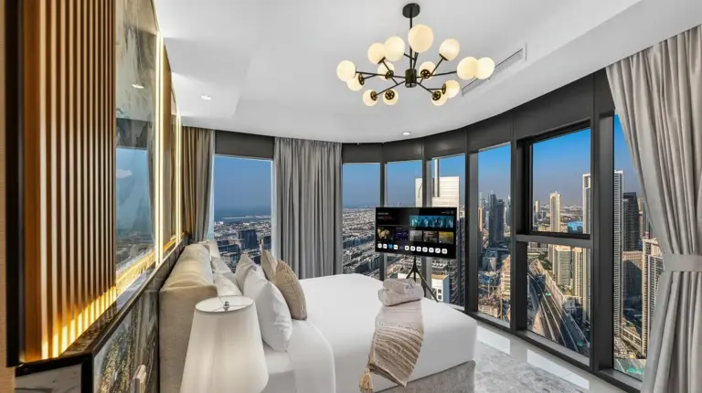 a bedroom with a white bed and large windows at Highest Infinity Pool in Downtown Dubai in Dubai