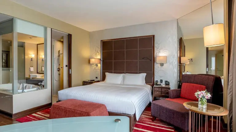 a hotel room with a bed and a bath tub at Hilton Bangkok Grande Asoke in Bangkok