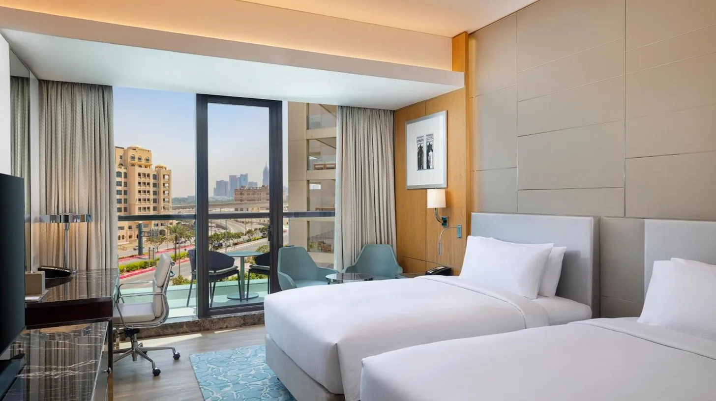 two beds in a hotel room with a view at Hilton Dubai Palm Jumeirah in Dubai