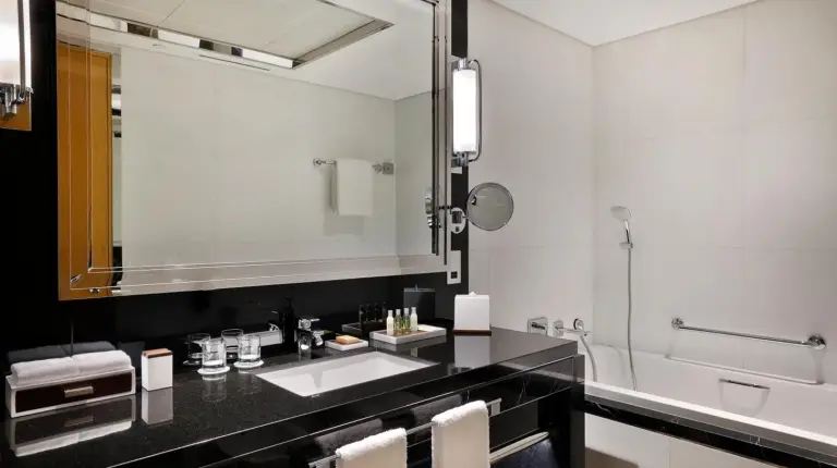a bathroom with a sink and a large mirror at Hilton Dubai Palm Jumeirah in Dubai