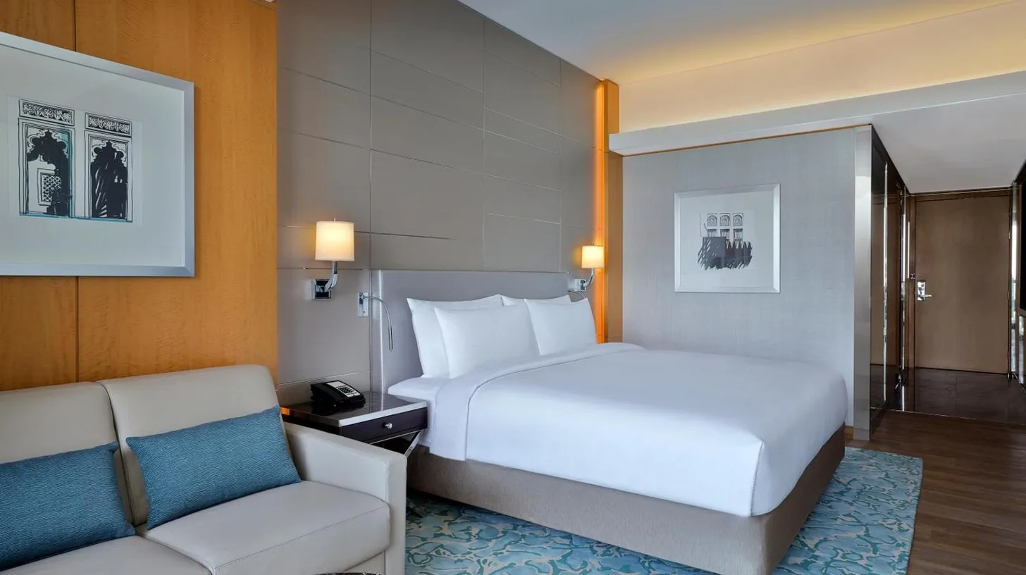 a hotel room with a bed and a couch at Hilton Dubai Palm Jumeirah in Dubai