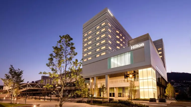 un gran edificio con luces encendidas en una ciudad en Hilton Nagasaki en Nagasaki