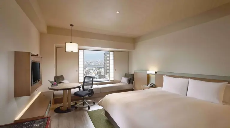 a hotel room with a large bed and a desk at Hilton Osaka Hotel in Osaka