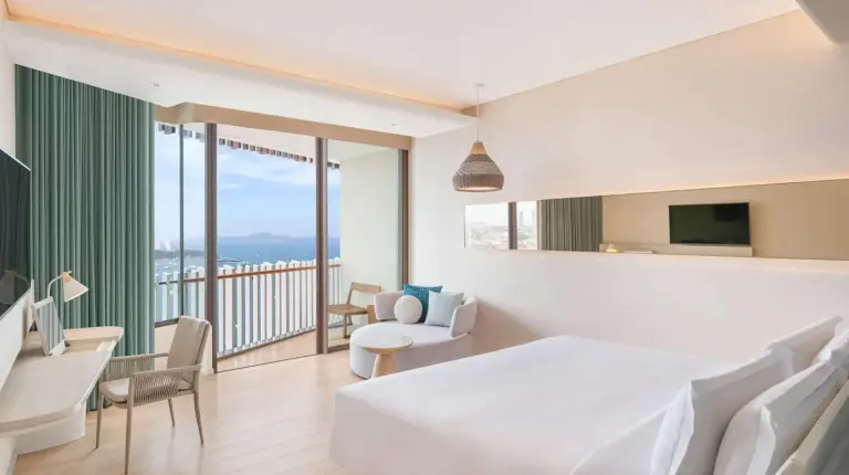 a hotel room with a large bed and a balcony at Hilton Pattaya in Pattaya Central