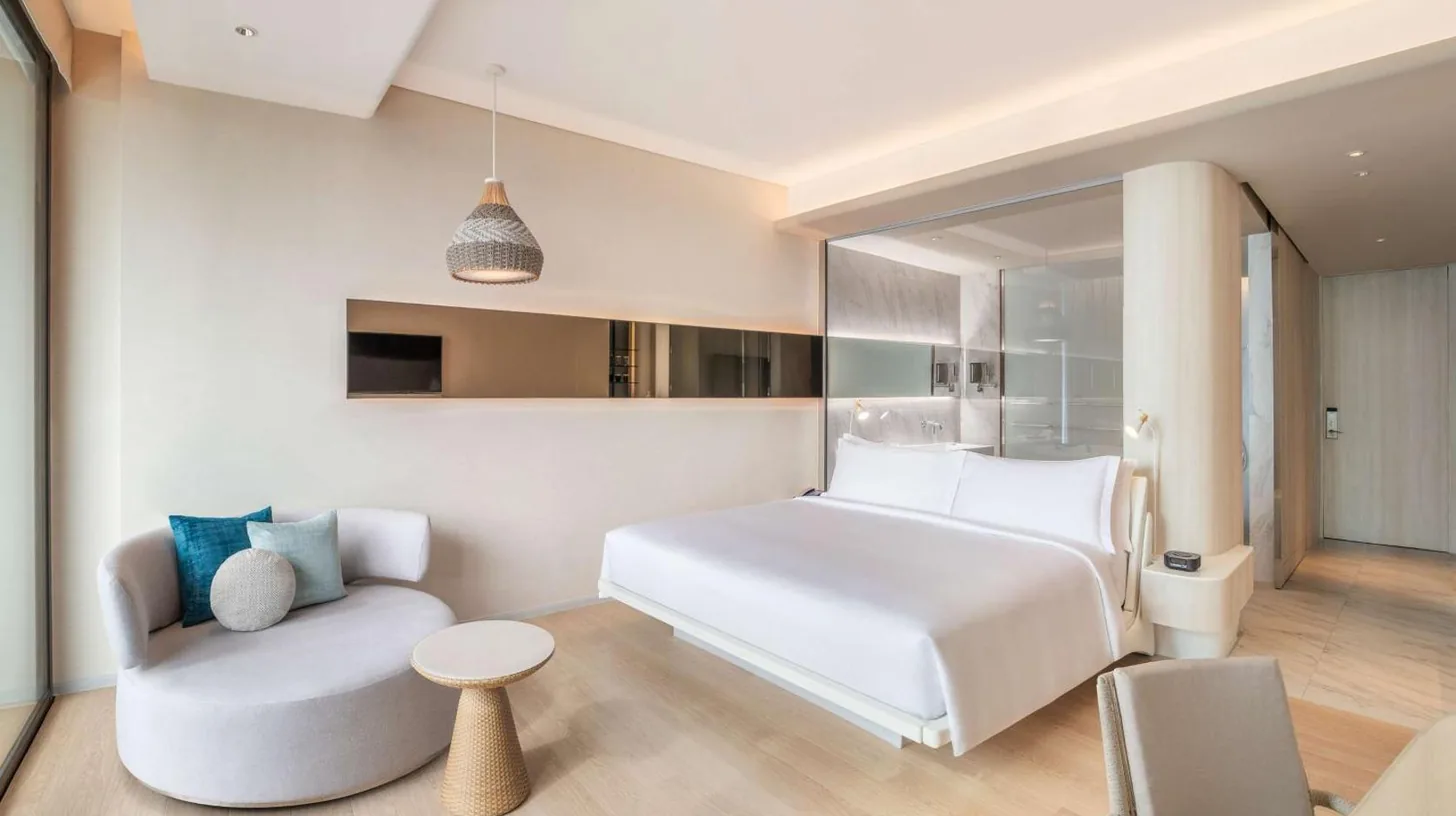 a bedroom with a white bed and a chair at Hilton Pattaya in Pattaya Central