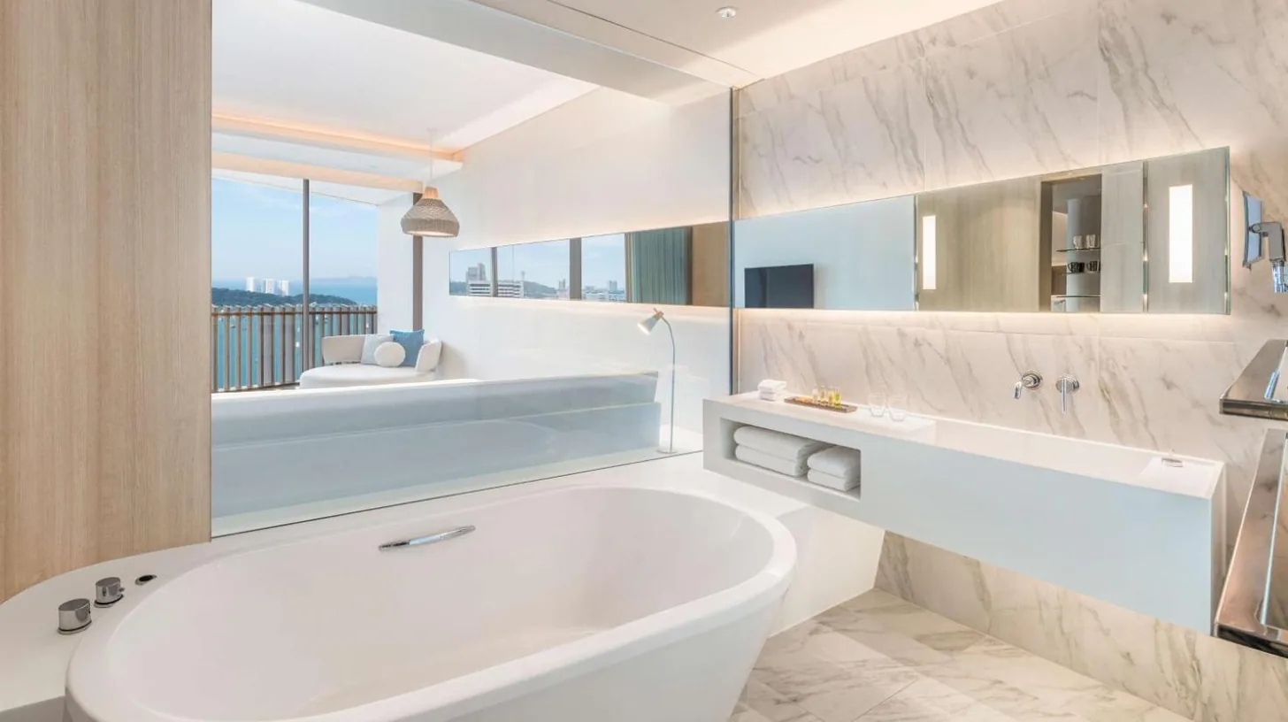 a white bathroom with a tub and a large window at Hilton Pattaya in Pattaya Central