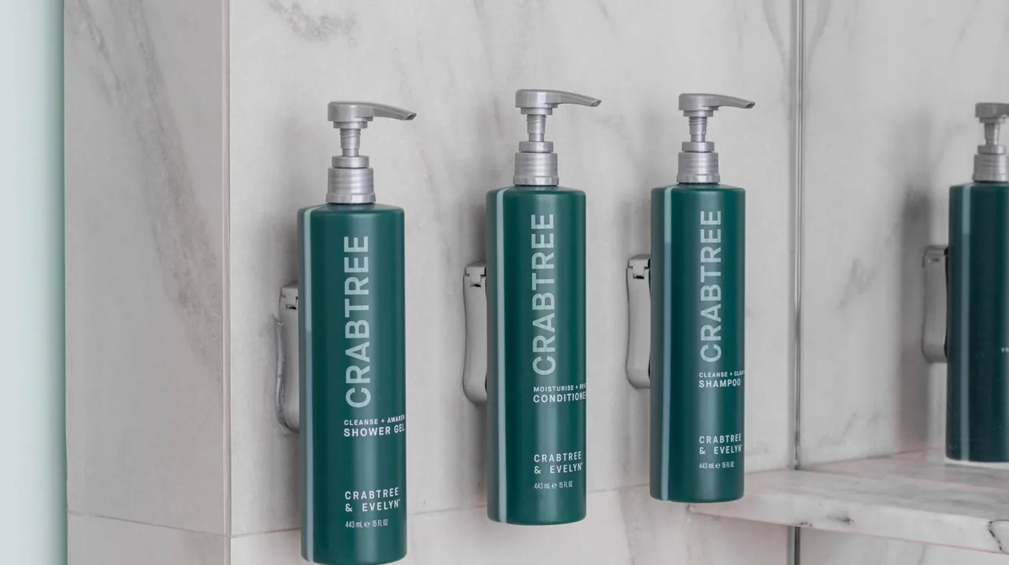 three green shampoo bottles on a shelf in a bathroom at Hilton Pattaya in Pattaya Central