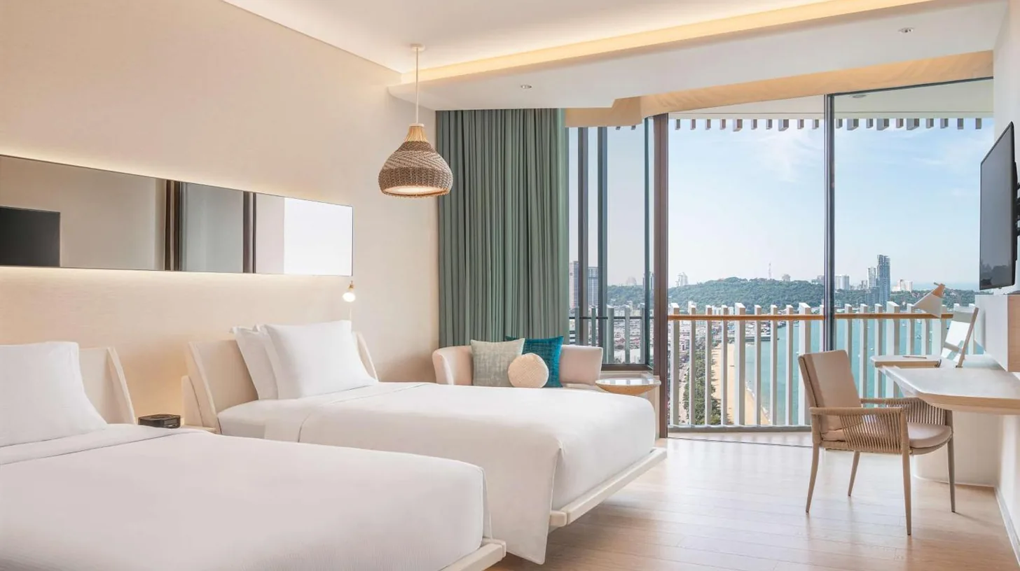 a hotel room with two beds and a balcony at Hilton Pattaya in Pattaya Central