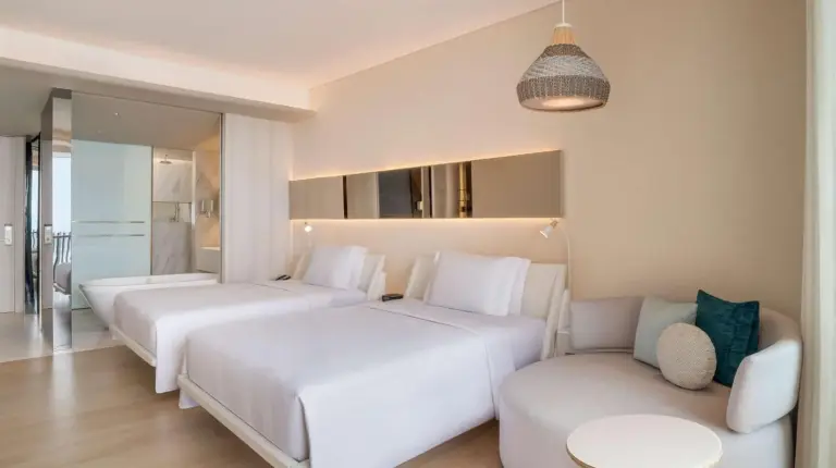 a hotel room with two beds and a couch at Hilton Pattaya in Pattaya Central
