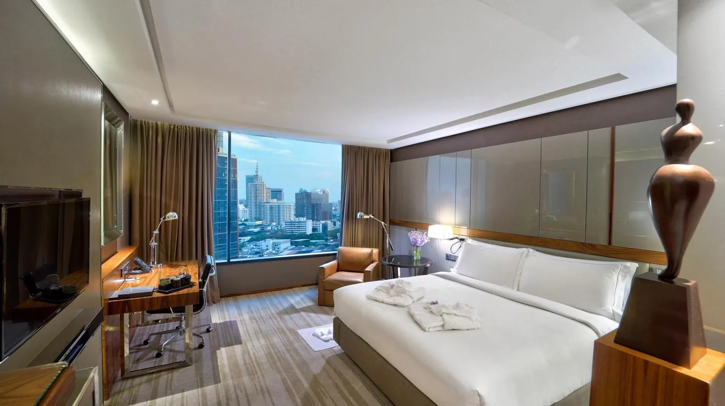 ein Wohnzimmer mit einer Couch und Stühlen im Hilton Sukhumvit Bangkok in Bangkok