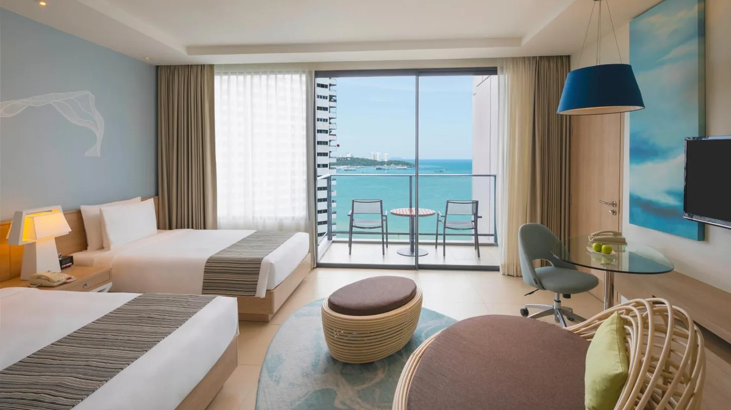 a bedroom with a large white bed and a desk at Holiday Inn Pattaya by IHG in Pattaya Central