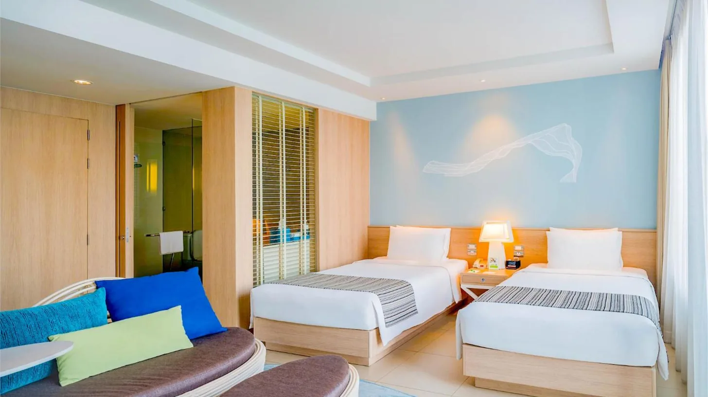 a bedroom with a large bed and two lamps at Holiday Inn Pattaya by IHG in Pattaya Central