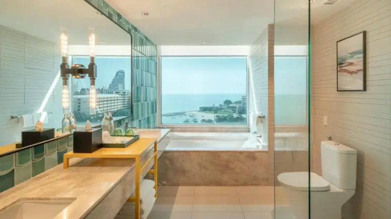 a hotel room with two beds and a desk at Holiday Inn Pattaya by IHG in Pattaya Central