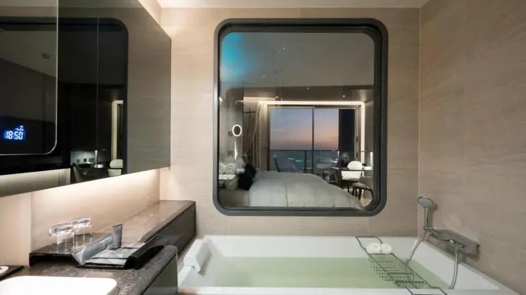 une salle de bain avec une baignoire, un lavabo et un miroir au Grande Centre Point Space Pattaya à Pattaya Nord