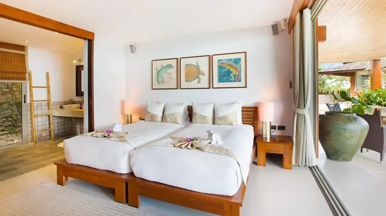 ein Schlafzimmer mit einem Bett mit weiÃen Laken und Kissen bei naked Home Baan Jakawan Koh Samui in Chaweng