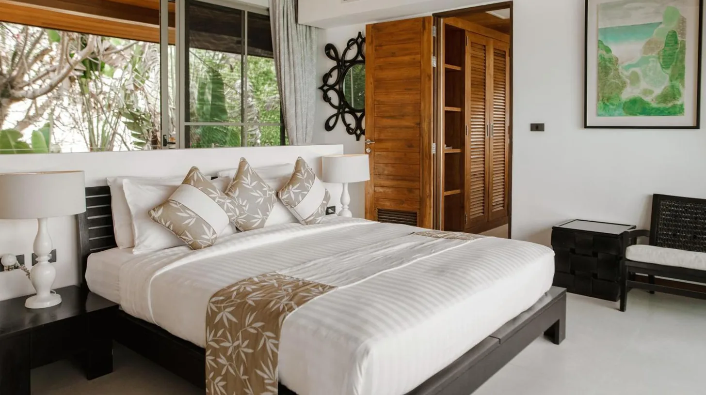 ein Schlafzimmer mit einem groÃen Bett und einem Fenster bei naked Home Baan Jakawan Koh Samui in Chaweng