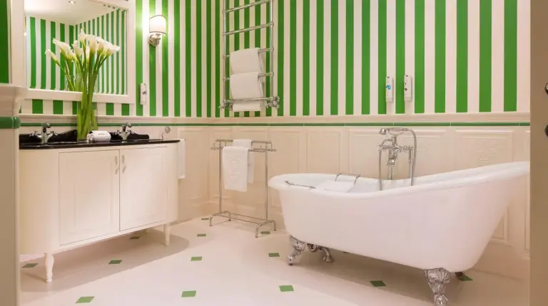 ein Schlafzimmer mit einem KingâSizeâBett und einem Tisch im Hotel Le Negresco in Nizza