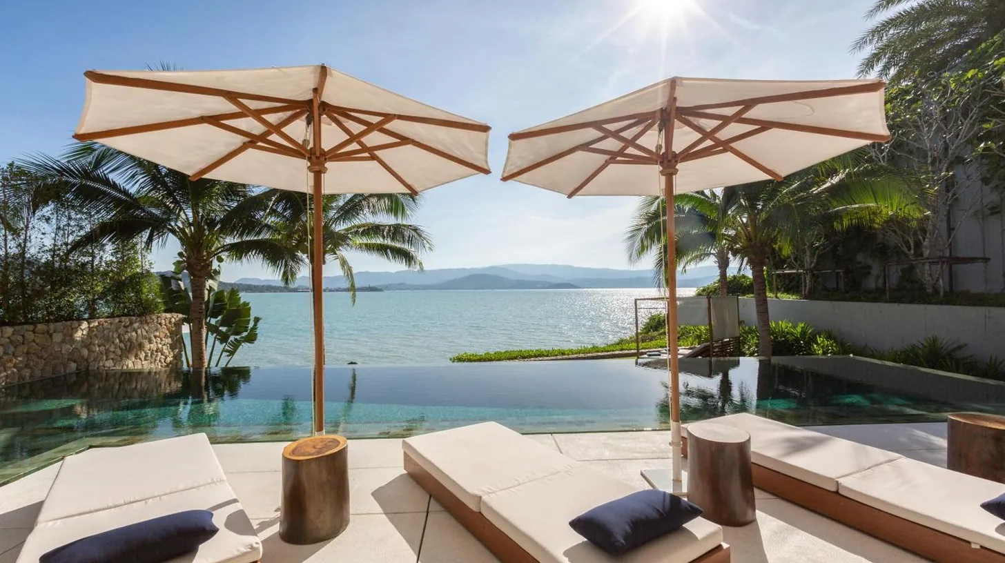a view of the ocean from a resort with umbrellas at Kerem Luxury Beachfront Villas in Choeng Mon Beach