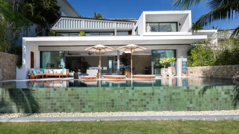 a house with a swimming pool with two umbrellas at Kerem Luxury Beachfront Villas in Choeng Mon Beach