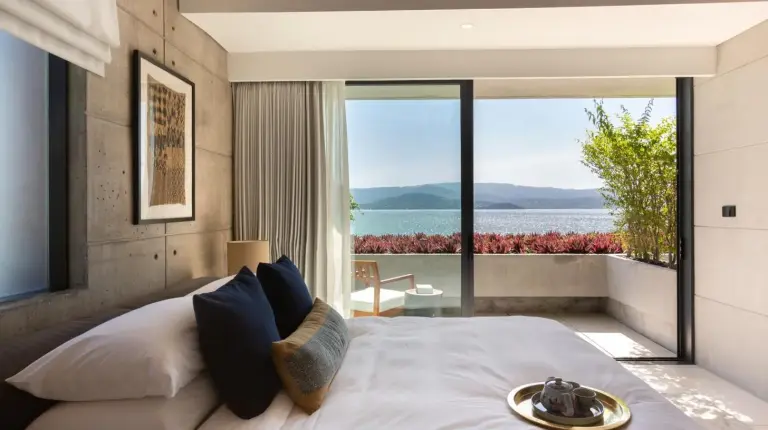 a bedroom with a large bed with a view of the ocean at Kerem Luxury Beachfront Villas in Choeng Mon Beach