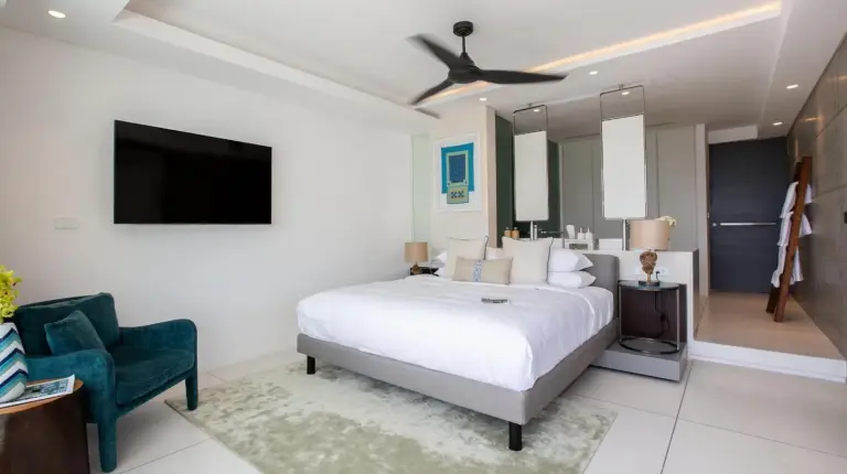 a bedroom with a bed and a tv and a chair at Kerem Luxury Beachfront Villas in Choeng Mon Beach