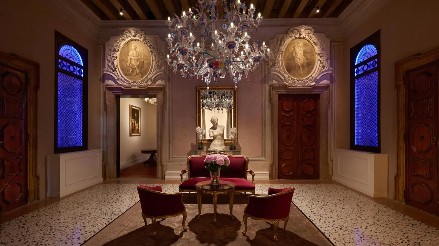una sala de estar con una araÃ±a y una mesa y sillas en Hotel Palazzo Giovanelli e Gran Canal en Venice