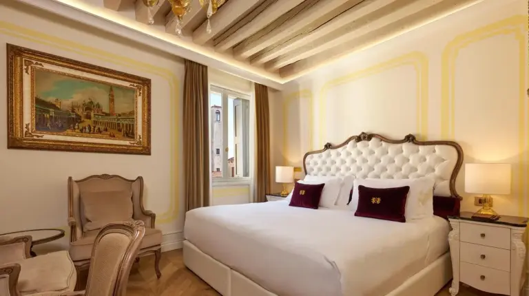 un dormitorio con una gran cama blanca y una silla en Hotel Palazzo Giovanelli e Gran Canal en Venice