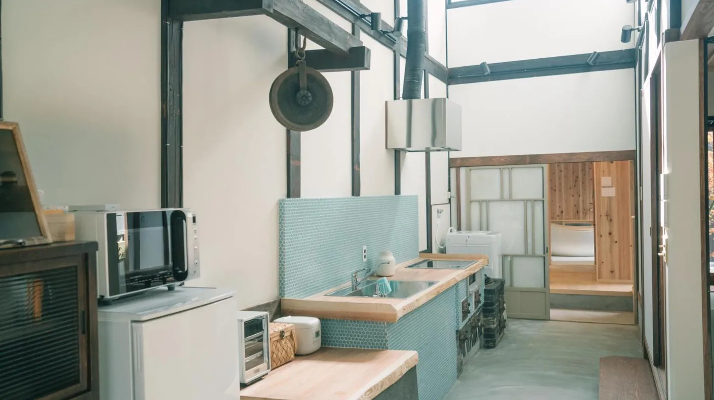 a bedroom with a bed with white sheets and pillows at Casa OGUMO in Kyoto