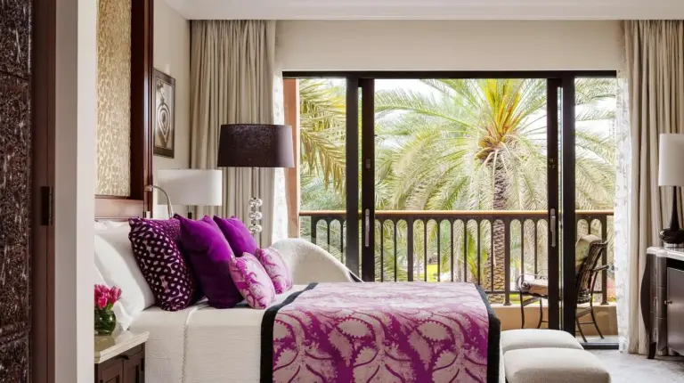 a hotel room with a bed and a balcony at One&Only Royal Mirage Resort Dubai in Dubai