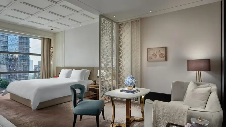 un dormitorio con una cama, un sofá y una mesa en Rosewood Bangkok en Bangkok