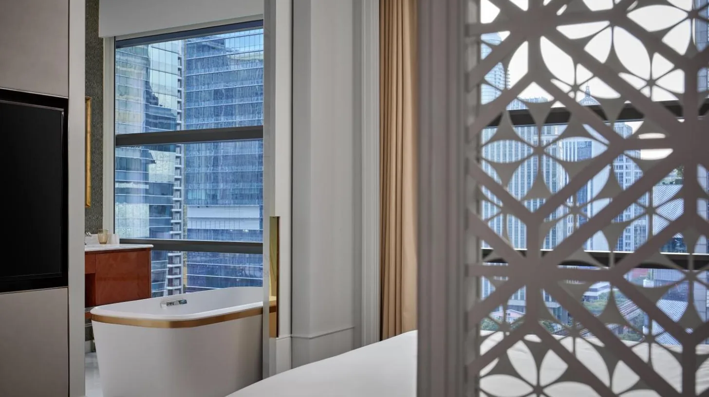 una sala de estar con una cama y una mesa en Rosewood Bangkok en Bangkok