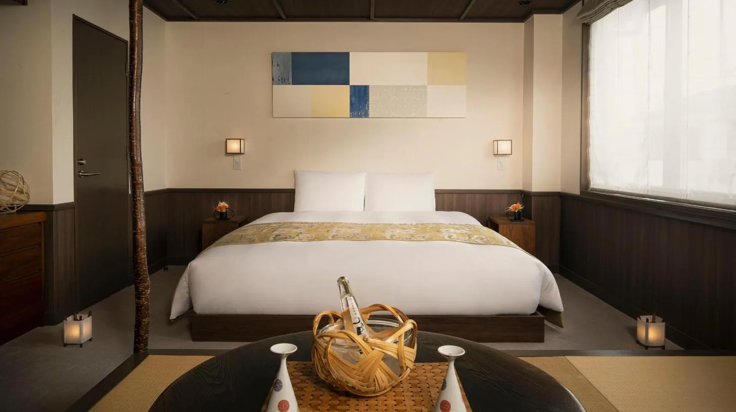 a bedroom with a bed and a table with a basket at THE JUNEI HOTEL Kyoto Imperial Palace West in Kyoto