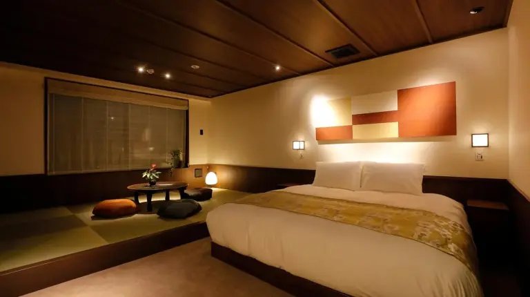 a bedroom with a large bed and a window at THE JUNEI HOTEL Kyoto Imperial Palace West in Kyoto