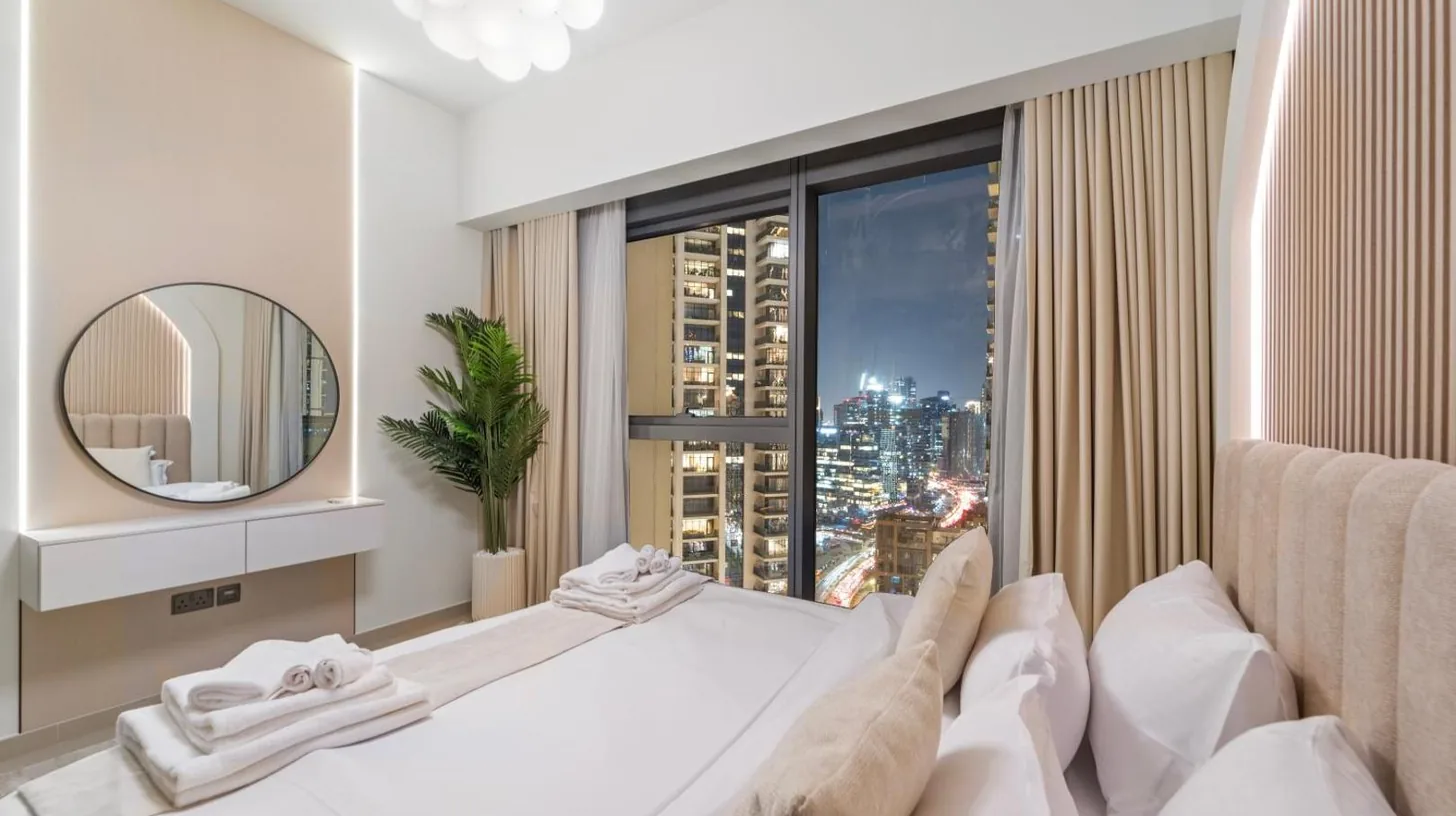 ein großes weißes Bett in einem Zimmer mit Spiegel im Modern stylish 2BR Apartment walk to Dubai Mall near Burj Khalifa in Dubai