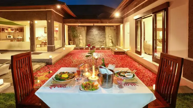 a table with plates of food on top of it at The Buah Bali Villas in Seminyak