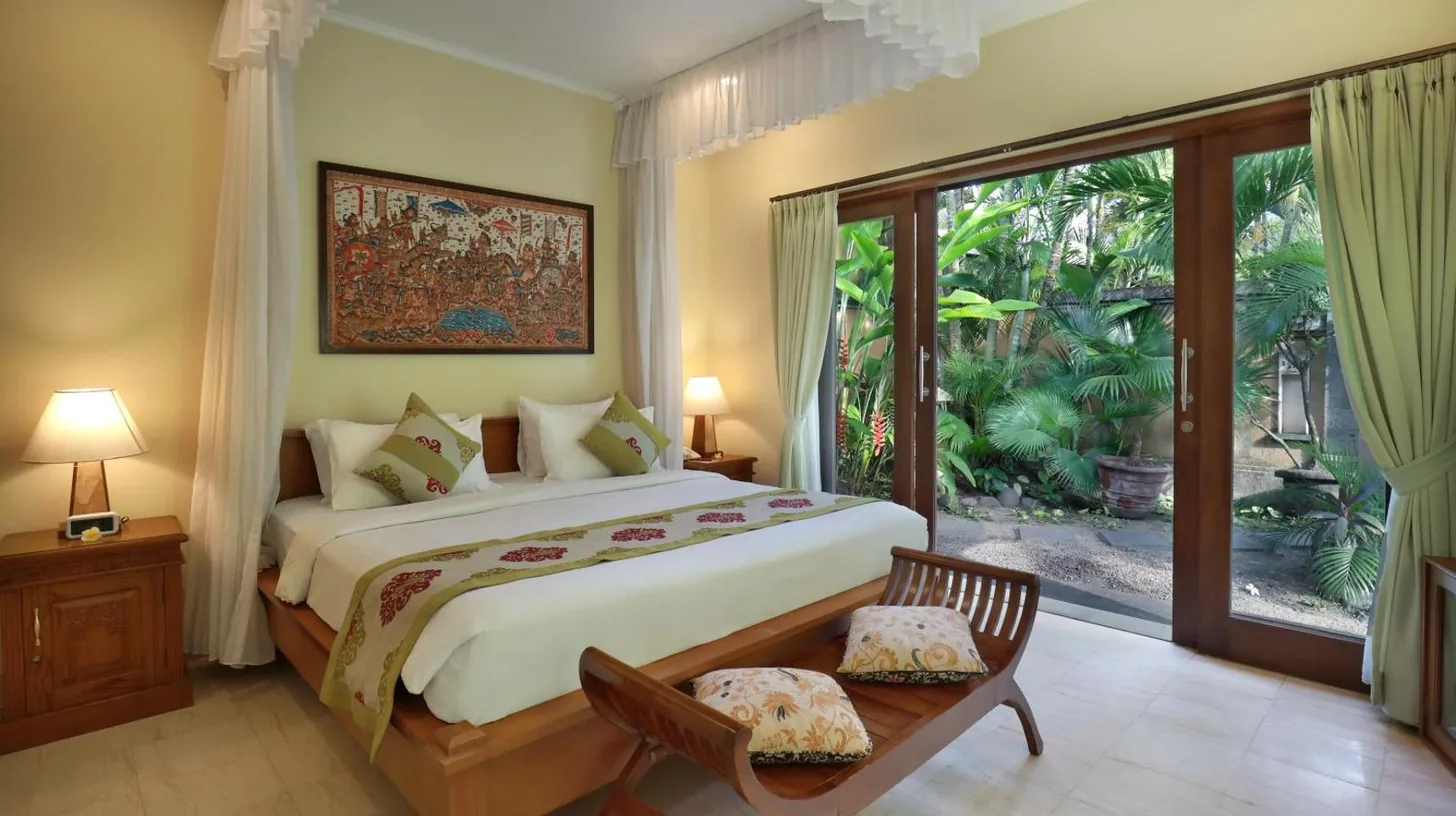 a bedroom with a large bed and a large window at The Buah Bali Villas in Seminyak