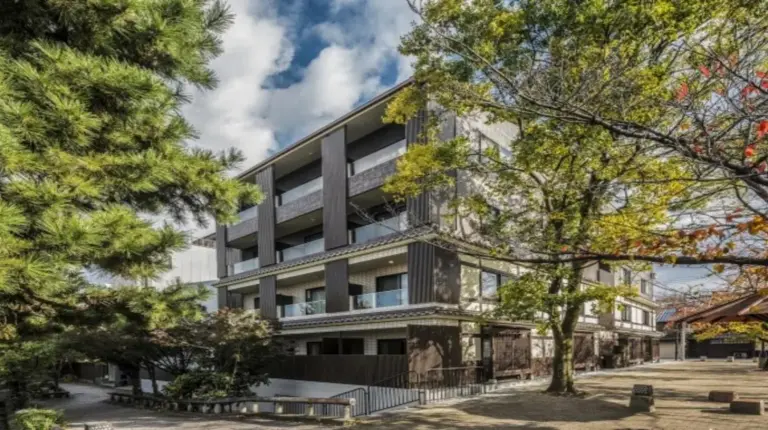 an office building with trees in front of it at Hotel Alza Kyoto in Kyoto