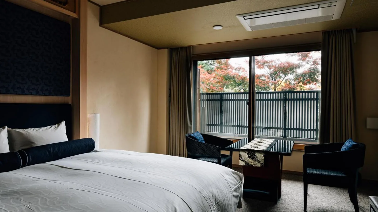 a bedroom with a bed and a desk and a window at Hotel Alza Kyoto in Kyoto