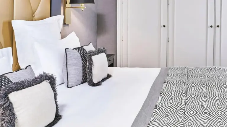 a bedroom with a bed with white sheets and pillows at Hôtel Barrière Le Majestic Cannes in Cannes