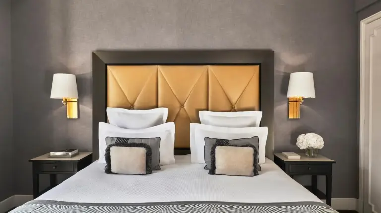a bedroom with a large bed with white pillows at Hôtel Barrière Le Majestic Cannes in Cannes