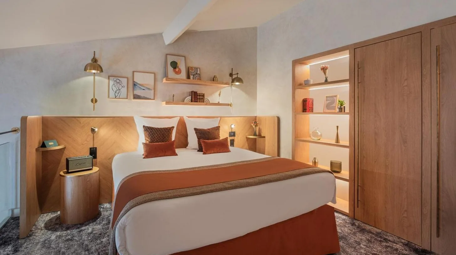 a bedroom with a large bed and some shelves at Hôtel Burdigala by Inwood Hotels in Bordeaux