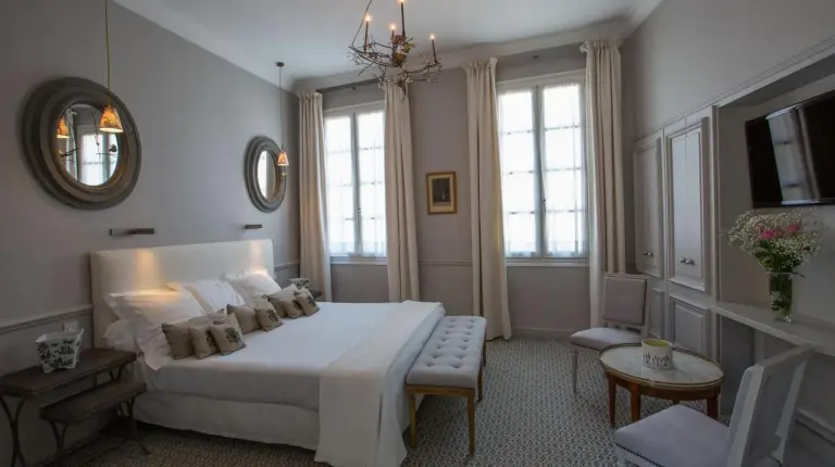 a living room with a couch and a bedroom at Hotel d'Europe in Avignon
