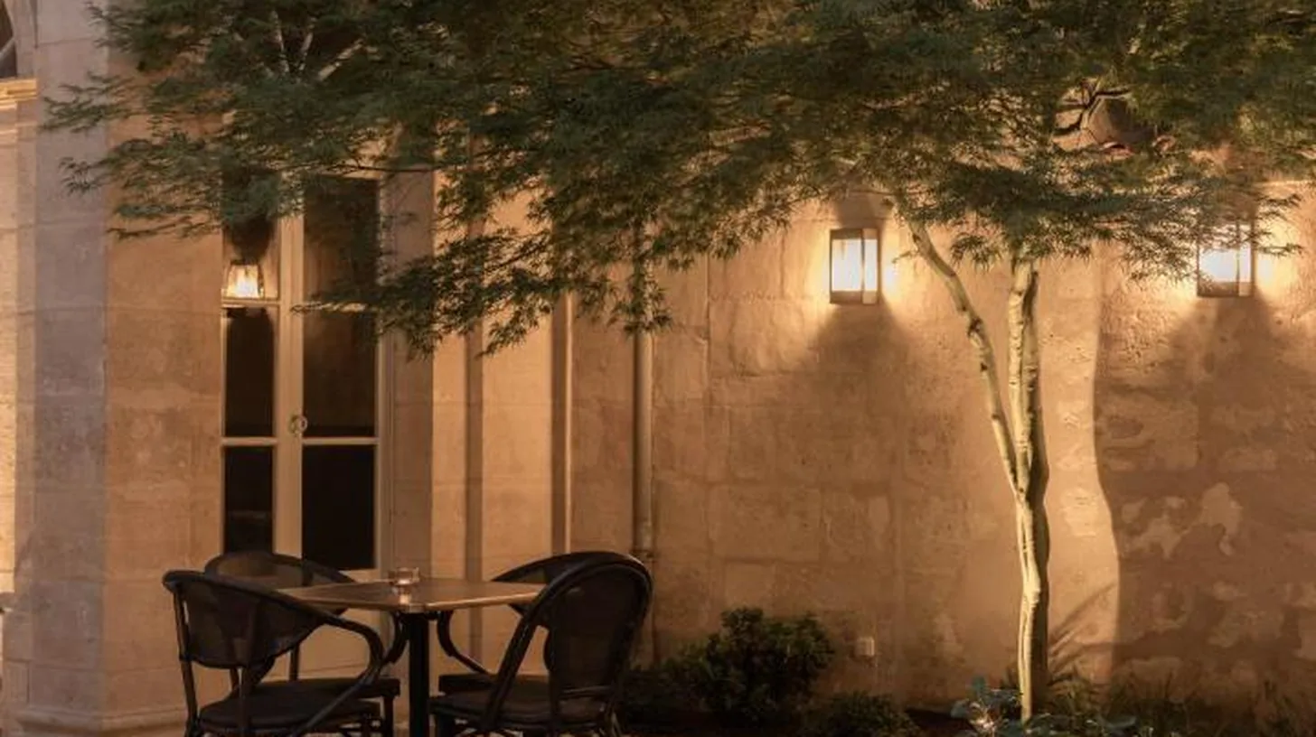a table and two chairs in front of a building at Hotel des Quinconces Bordeaux Centre in Bordeaux