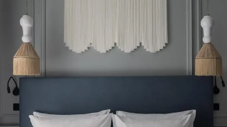 a bedroom with a white bed with pillows and a painting at Hotel des Quinconces Bordeaux Centre in Bordeaux