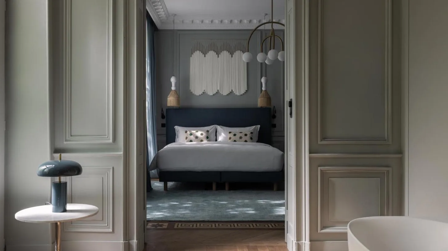 a bedroom with a bed with a blue headboard at Hotel des Quinconces Bordeaux Centre in Bordeaux
